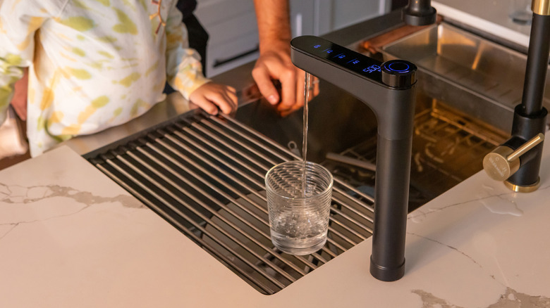 kitchen sink with the Waterdrop Filter X16 smart faucet filling a glass of water for a kid and father